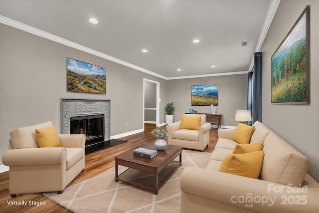 living room with baseboards, crown molding, wood finished floors, and recessed lighting
