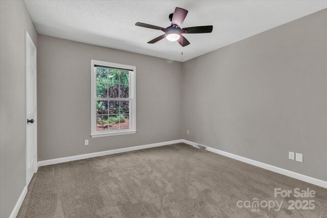 unfurnished room featuring carpet flooring, a ceiling fan, baseboards, and visible vents