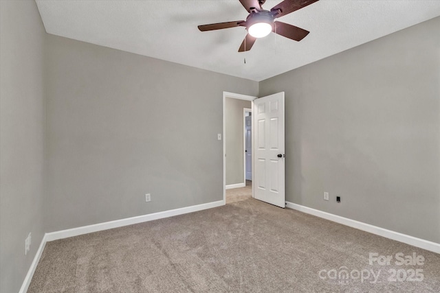 carpeted empty room featuring baseboards and ceiling fan