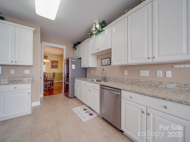 kitchen featuring light tile patterned floors, stainless steel appliances, white cabinets, a sink, and light stone countertops