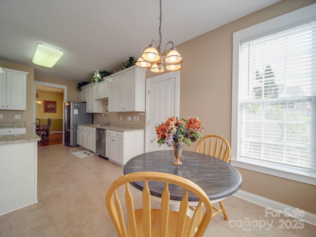 dining room featuring a notable chandelier, baseboards, and light tile patterned floors