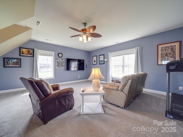 carpeted living room featuring ceiling fan, visible vents, vaulted ceiling, and baseboards