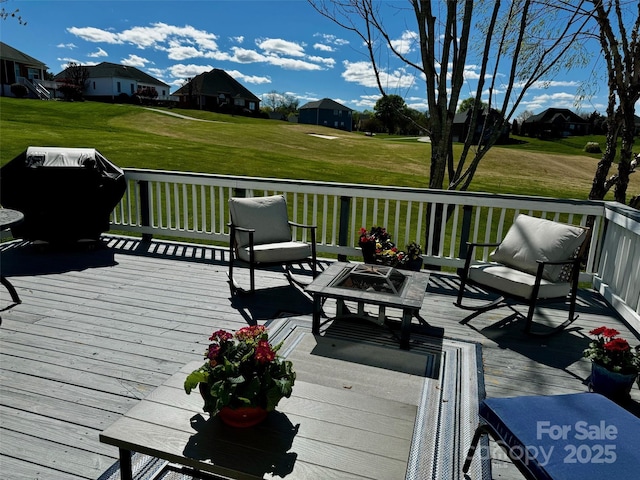 wooden deck with a yard, a grill, and a residential view