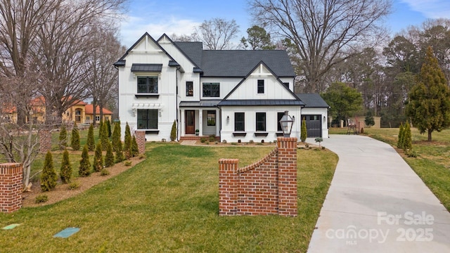 modern inspired farmhouse with concrete driveway, a front lawn, a standing seam roof, and board and batten siding