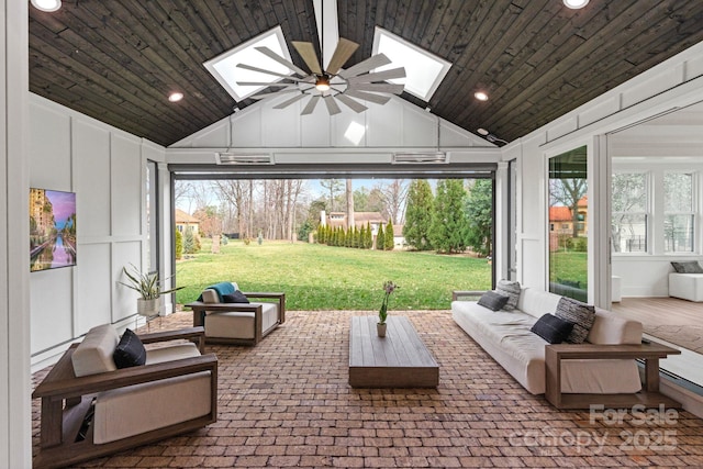 sunroom / solarium with wooden ceiling, vaulted ceiling with skylight, and ceiling fan