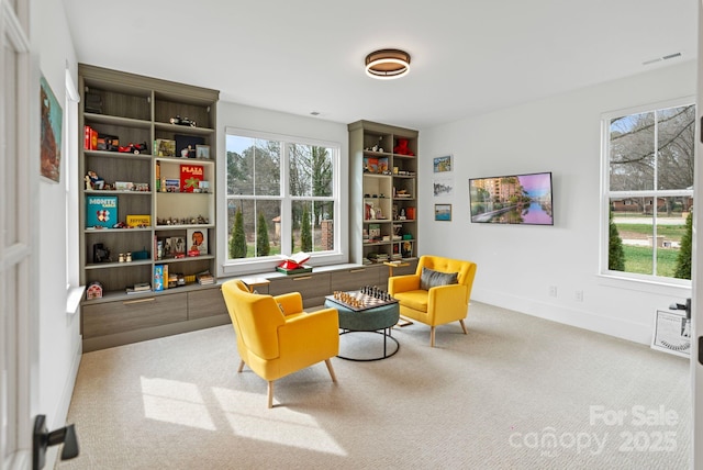 sitting room with carpet, visible vents, and baseboards