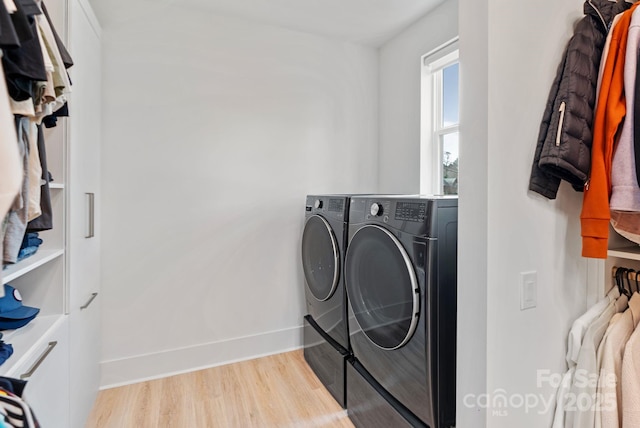 laundry room featuring washer and dryer, laundry area, baseboards, and light wood finished floors