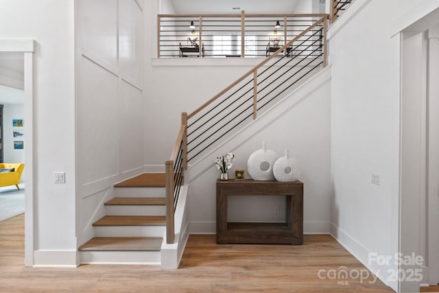 staircase featuring baseboards and wood finished floors