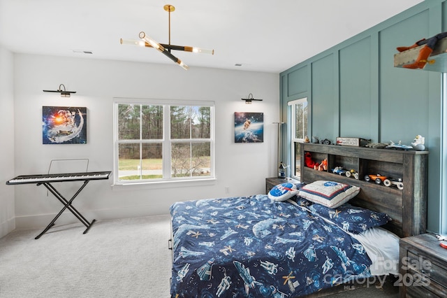 carpeted bedroom with visible vents and a decorative wall