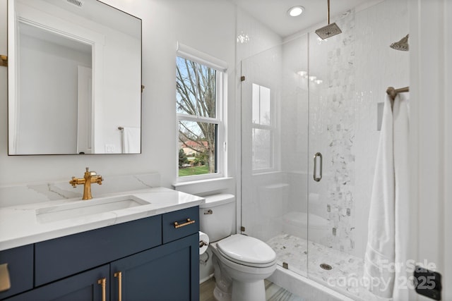 bathroom featuring a healthy amount of sunlight, a shower stall, and toilet