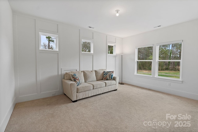 living area featuring baseboards, visible vents, and carpet flooring