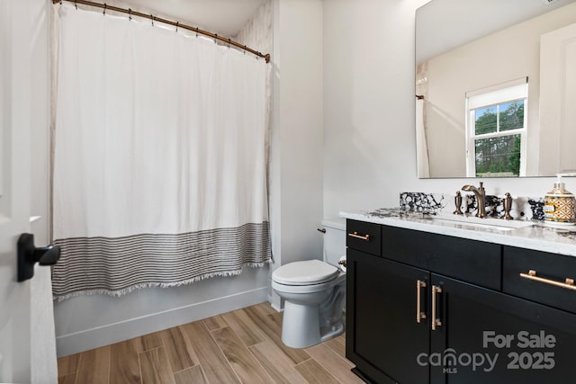 full bathroom with vanity, shower / bath combo, wood finished floors, and toilet