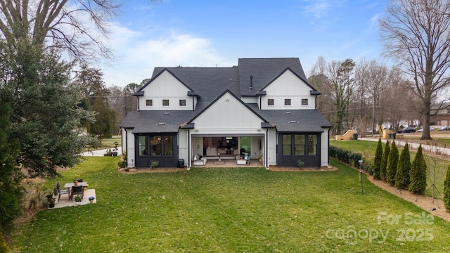 back of property featuring board and batten siding, roof with shingles, a patio, and a lawn