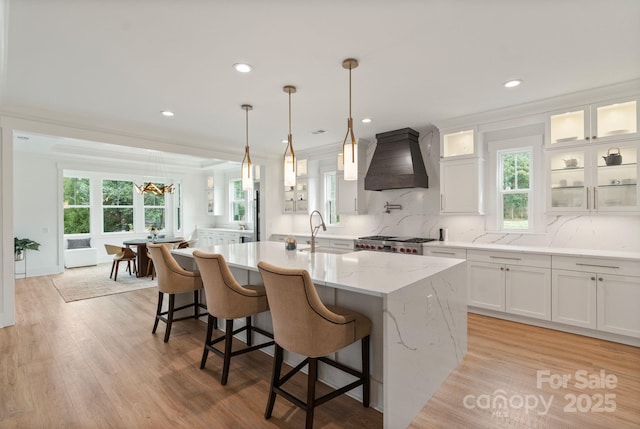 16112 Terry Ln, Huntersville, NC 28078 - kitchen featuring white cabinets, a sink, a kitchen island with sink, and premium range hood