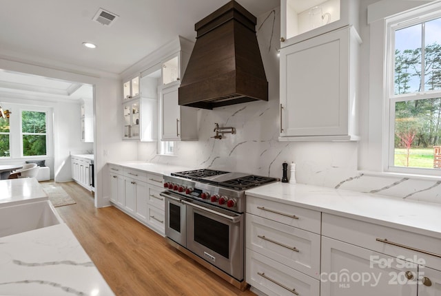 16112 Terry Ln, Huntersville, NC 28078 - kitchen with double oven range, tasteful backsplash, white cabinets, custom range hood, and light wood-type flooring