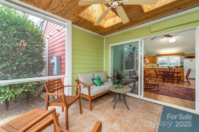 sunroom / solarium with a skylight, wooden ceiling, and a ceiling fan