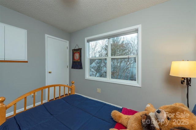 bedroom featuring a textured ceiling and baseboards