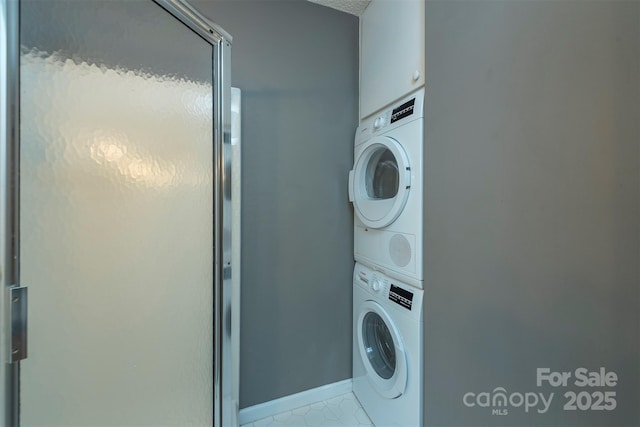 washroom featuring stacked washer and dryer and laundry area