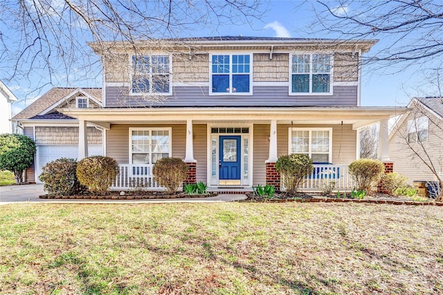 view of front of house with an attached garage, a porch, and a front yard