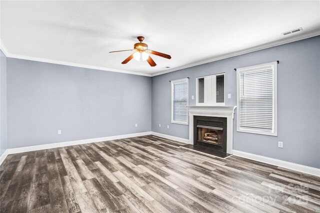 unfurnished living room with crown molding, a fireplace, visible vents, and baseboards