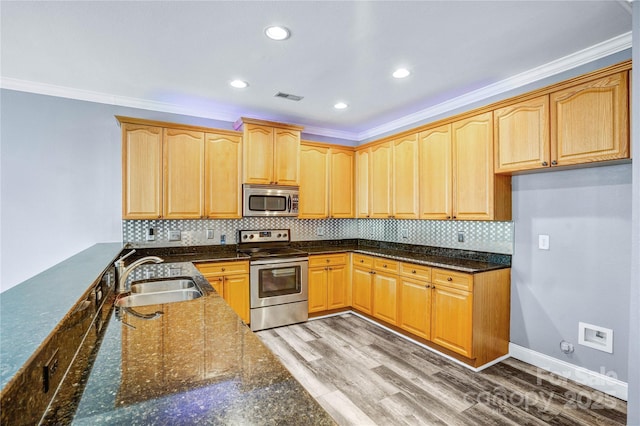 kitchen featuring light wood-type flooring, visible vents, a sink, tasteful backsplash, and stainless steel appliances