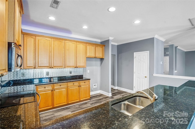 kitchen with stainless steel microwave, visible vents, crown molding, baseboards, and a sink