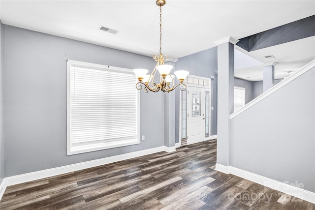 unfurnished dining area featuring visible vents, dark wood-type flooring, an inviting chandelier, baseboards, and stairs