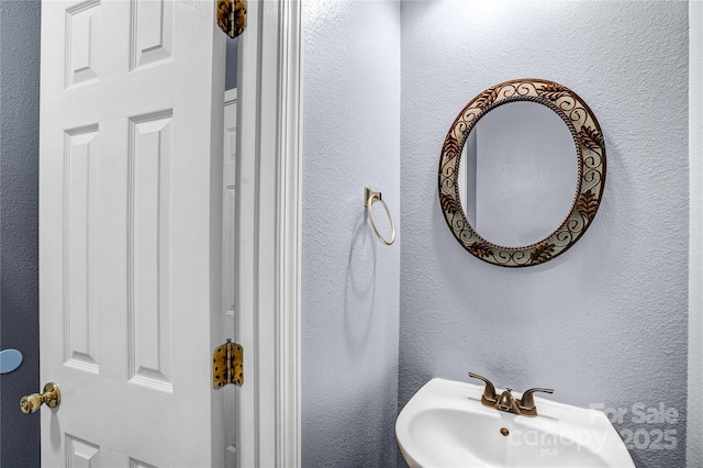 bathroom with a sink and a textured wall