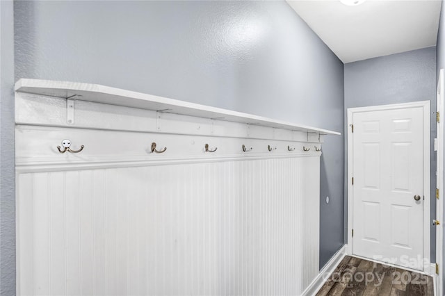 mudroom with dark wood-style floors and baseboards