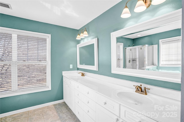 bathroom featuring visible vents, a shower stall, baseboards, and a sink