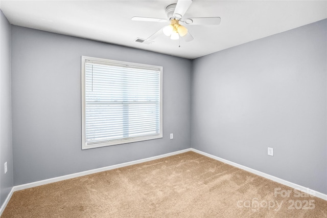 carpeted empty room with a ceiling fan, visible vents, and baseboards