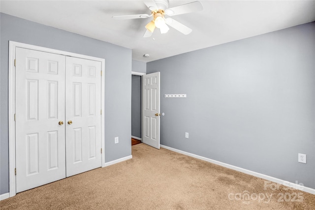 unfurnished bedroom featuring ceiling fan, baseboards, a closet, and light carpet