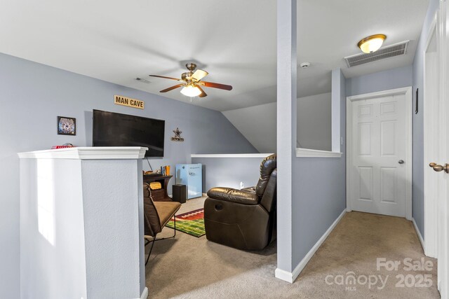 carpeted living room featuring baseboards, visible vents, vaulted ceiling, and attic access