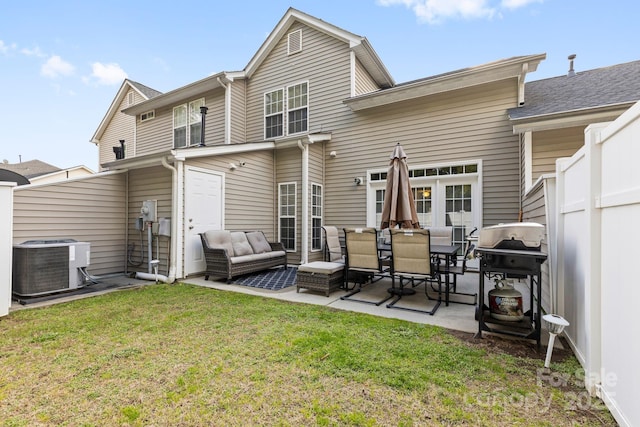 back of property featuring a patio, central air condition unit, outdoor lounge area, fence, and a yard