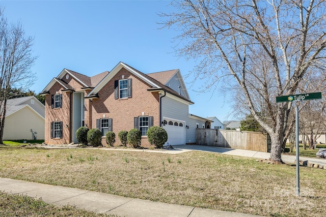 traditional home with driveway, fence, a front lawn, and brick siding