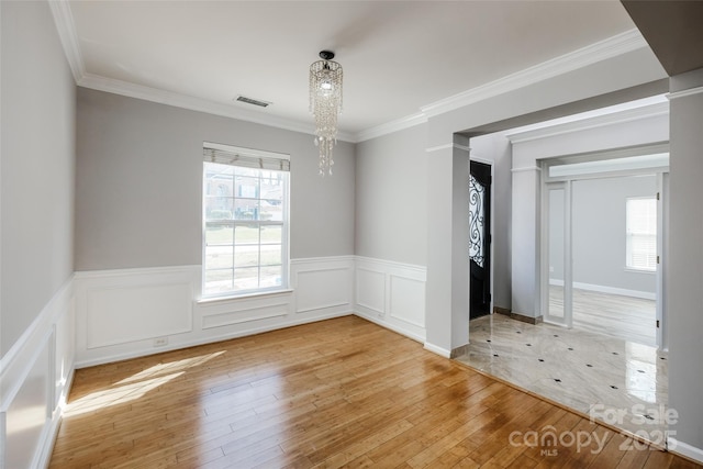 empty room with an inviting chandelier, plenty of natural light, visible vents, and light wood-style floors