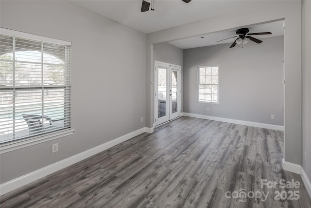 unfurnished room with a ceiling fan, french doors, baseboards, and wood finished floors