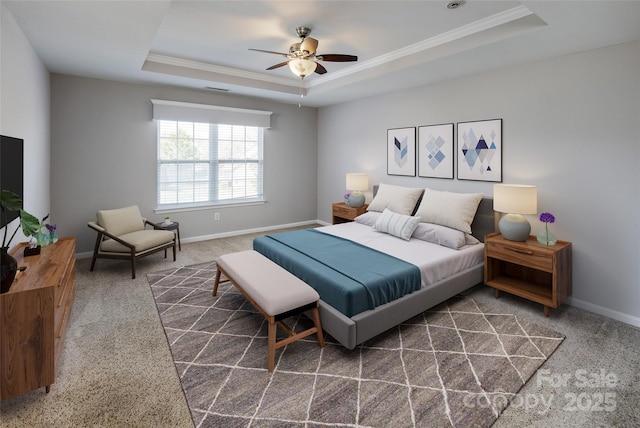 bedroom featuring ornamental molding, a tray ceiling, and baseboards