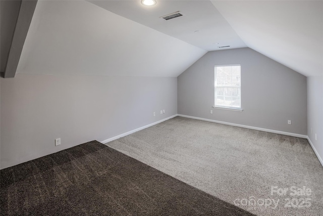 bonus room with baseboards, visible vents, vaulted ceiling, and carpet flooring