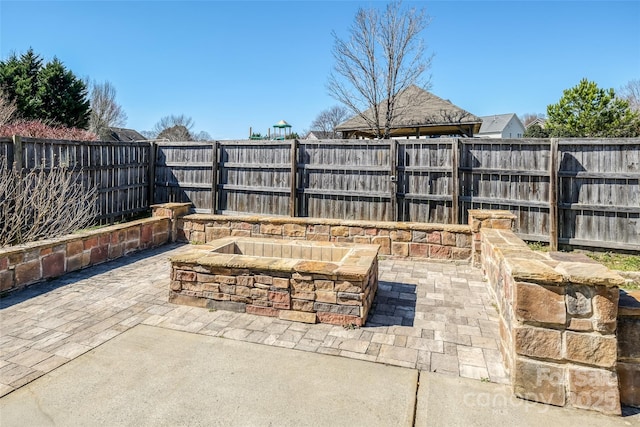 view of patio featuring a fenced backyard and a fire pit