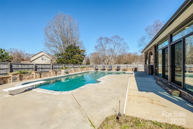 view of pool featuring a fenced backyard, a diving board, a fenced in pool, and a patio