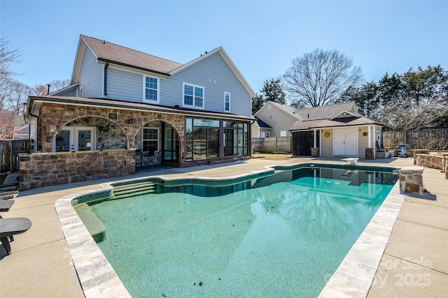 view of swimming pool featuring a patio area, a fenced backyard, a fenced in pool, and an outdoor structure