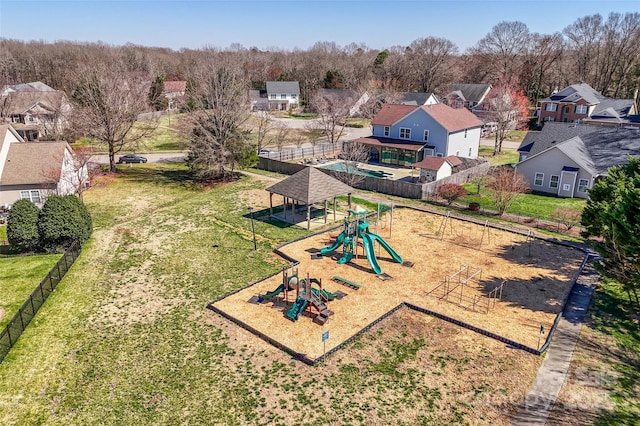 view of home's community featuring a residential view, fence, a playground, and a yard