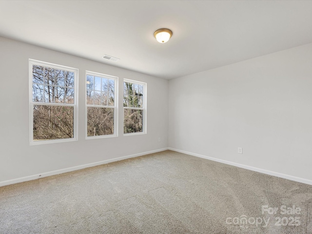 carpeted spare room featuring visible vents and baseboards