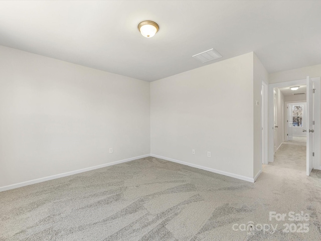 empty room featuring baseboards, visible vents, and light colored carpet