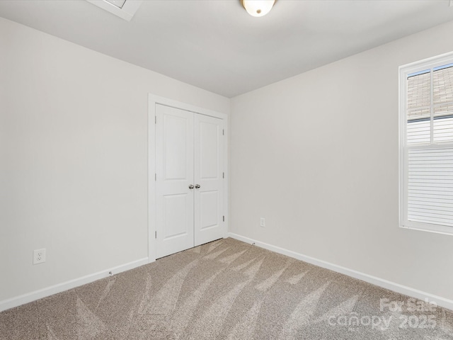 unfurnished bedroom featuring a closet, carpet, and baseboards