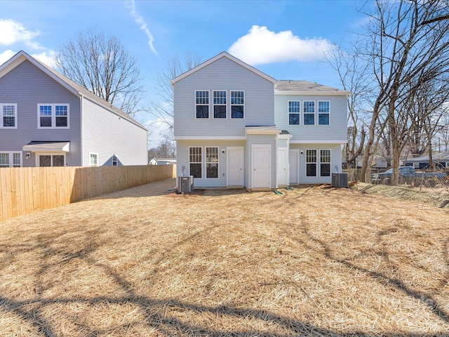 rear view of property featuring a lawn, fence private yard, and central air condition unit