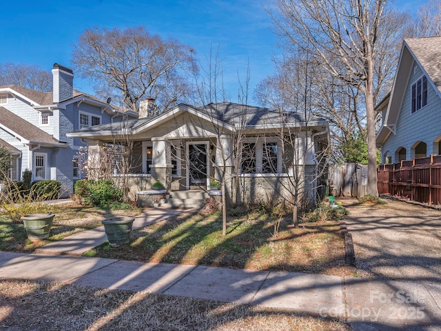 view of front of house featuring covered porch and fence