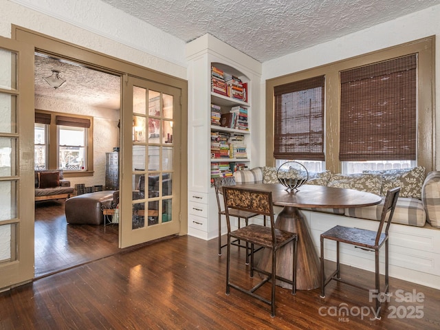 dining space featuring wood-type flooring and a textured ceiling