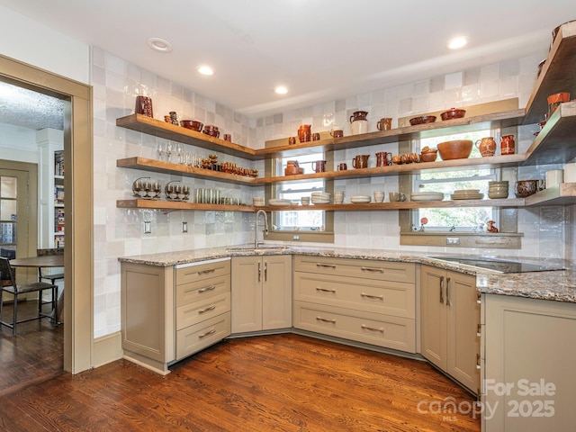 kitchen with dark wood-type flooring, black electric stovetop, open shelves, and a sink